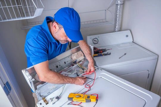 Technician inspecting the wiring behind a top-loading washer control panel